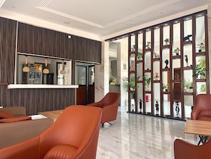 A modern hotel lobby with a seating area, a refreshment bar, and a decorative partition with plants. - Standard "All-Comfort" Room in Dakar: Excellent Value for the Money (Dakar)