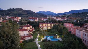 Zona residencial con casas, piscina y montañas al fondo.