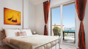 Un dormitorio con cama, un cuadro, una ventana con cortinas y vistas al exterior.