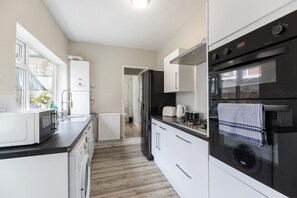 Eine moderne Küche mit Einbauofen, Mikrowelle und Kühlschrank.