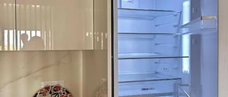 Ein offener Kühlschrank mit mehreren Ablagen und einem Gefrierfach.