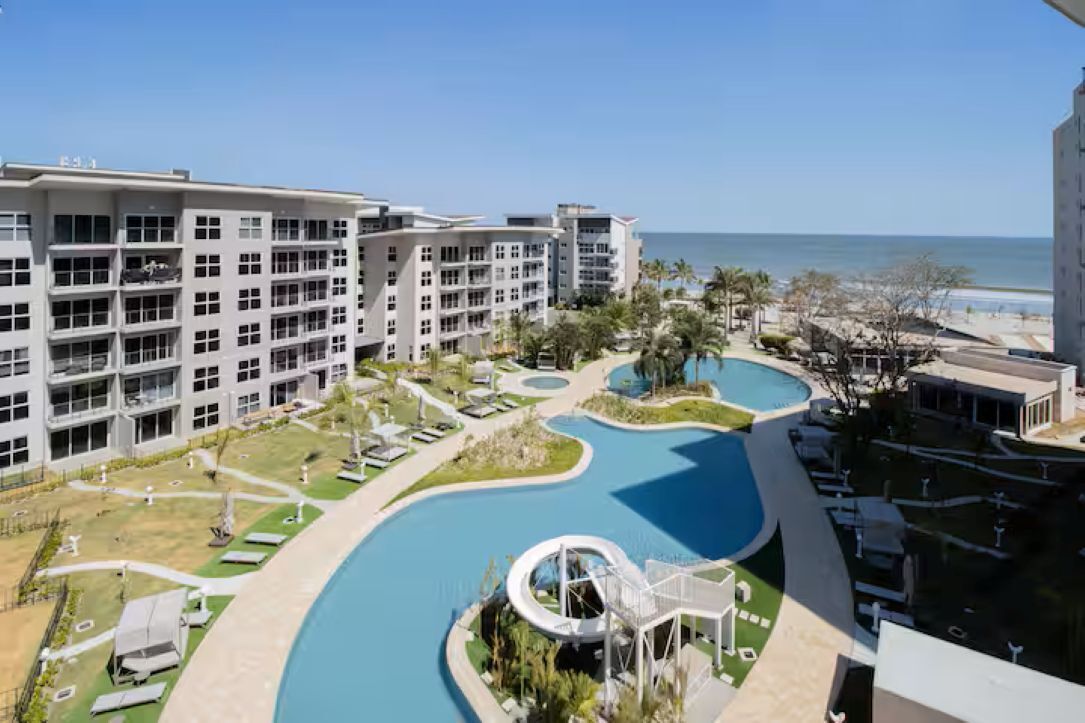 Ein Hotel mit mehreren Etagen, einem Schwimmbad und Blick auf den Ozean.