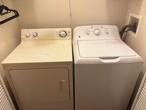 Two stacked washing machines in a laundry room.