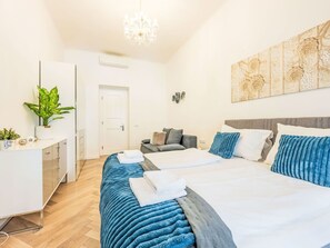 Ein modernes Schlafzimmer mit Bett, Nachttischen, einem Schreibtisch und einer Zimmerpflanze.