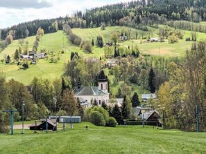 Ländliche Landschaft mit Kirche, Häusern und einem Hügel.