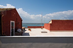 Ein Gebäude mit rotem Dach und Blick auf das Meer und Boote.
