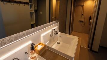 A modern bathroom with a large bathtub, a sink, and a shower.