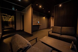 A dimly lit room with a reception desk, a sofa, and a bench. - Hoshino Hikarino Yado Biei (Kamikawa-gun)