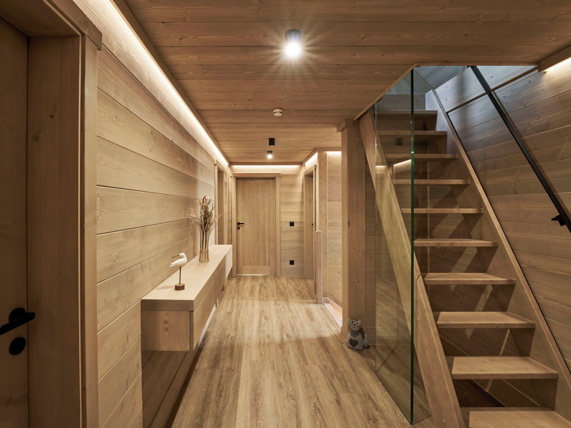 A wooden interior with a staircase and a hallway.