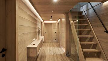 A wooden interior with a staircase and a hallway.