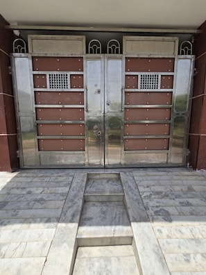 A set of double metal gates with a central step leading up to a building entrance. - Fantastic 3-bedroom Guest house with AC in enchanting Agra (Agra)
