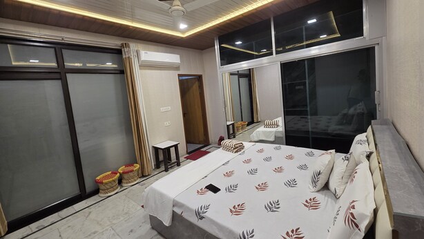 Habitación de hotel moderna con una cama grande, una mesita, un espejo y un vidrio corredero que da a un balcón.