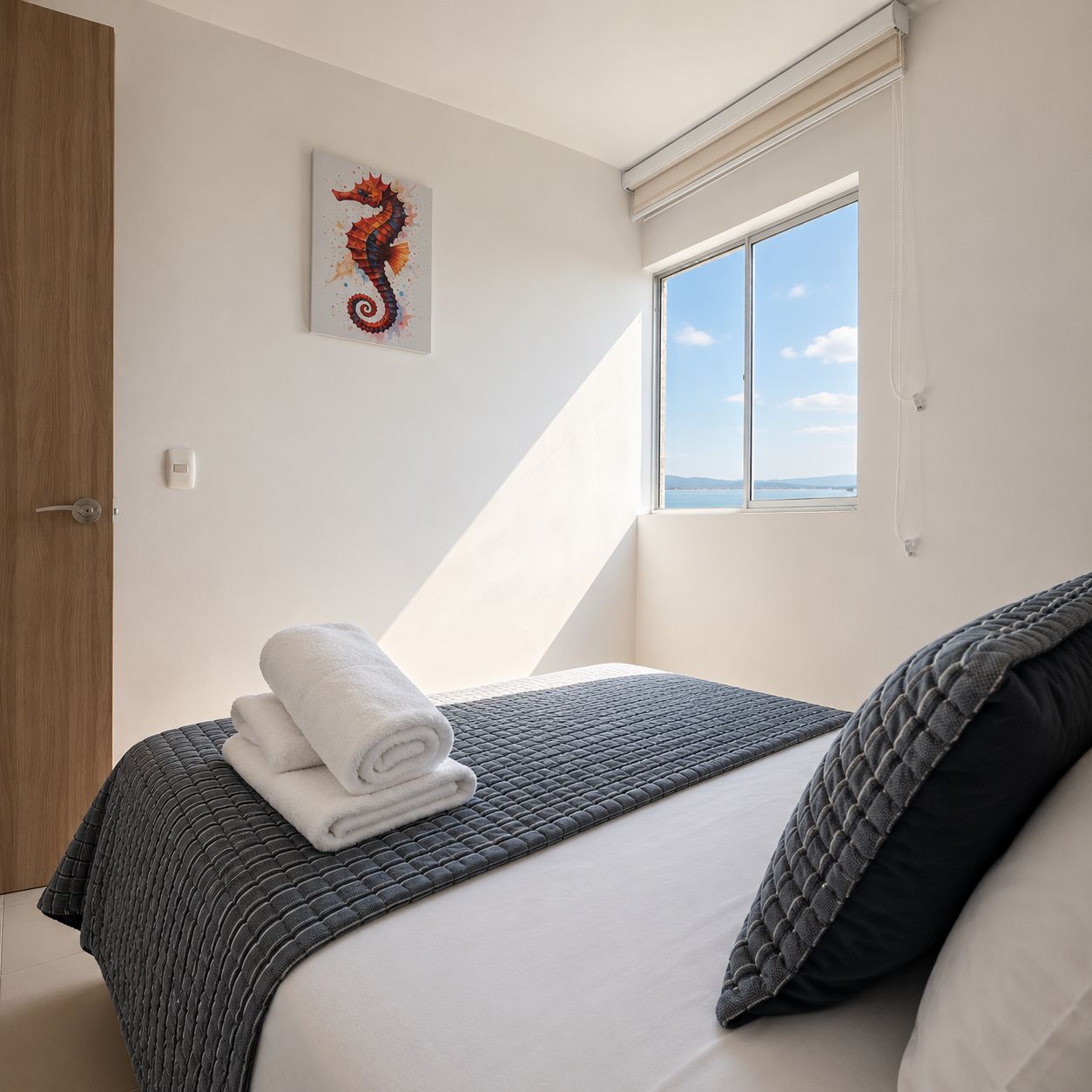 Ein Schlafzimmer mit Bett, Fenster mit Blick, Tür und einem an der Wand befestigten Thermostat.