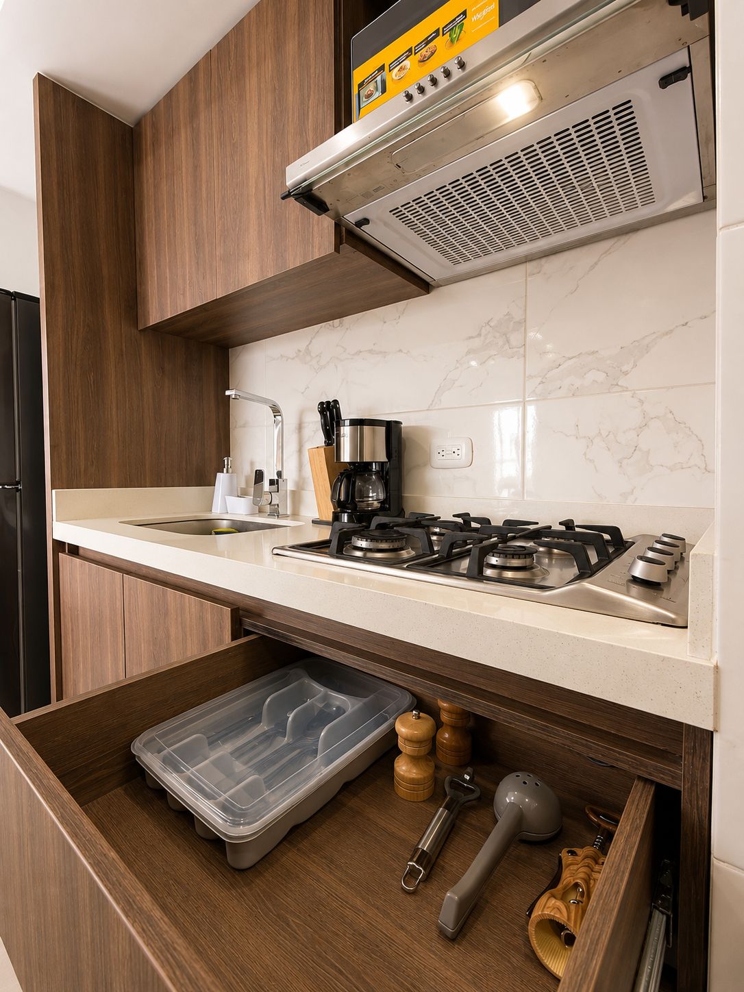 A modern kitchen with a gas stove, a coffee maker, and a built-in oven.