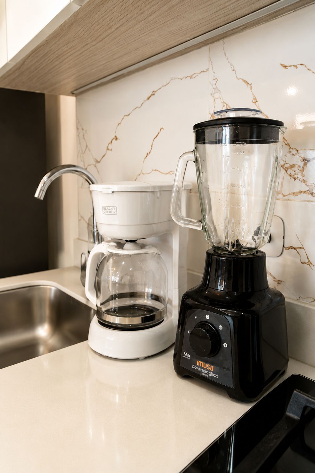A kitchen with a coffee maker and a blender on the counter.