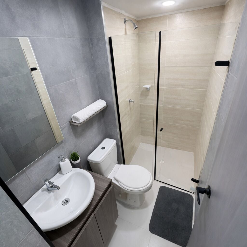 A modern bathroom with a sink, toilet, and shower.