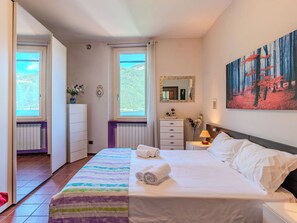 Ein Schlafzimmer mit Bett, Schminktisch, Spiegel und einem Gemälde an der Wand.