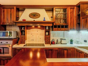 Eine Küche mit Holzausstattung, einer Mikrowelle, einem Wasserkocher und einem Toaster.