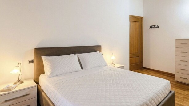 Ein Schlafzimmer mit Bett, Nachttischen, einem Schminktisch und Holzboden.
