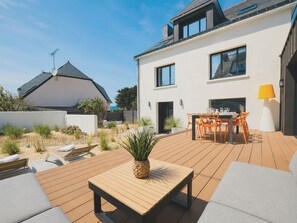 A modern house with a patio, outdoor seating, and a dining area. - A Chic Getaway in Kerroc'h. The ocean is just a few steps away (Ploemeur)