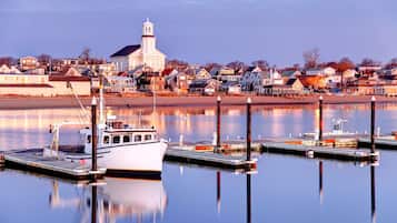Une ville située au bord de l’eau, avec un bateau amarré, une église et des immeubles d’habitation.