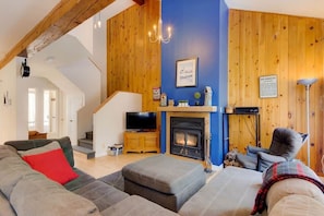 Ein Wohnzimmer mit Kamin, Fernseher und einer Couch.