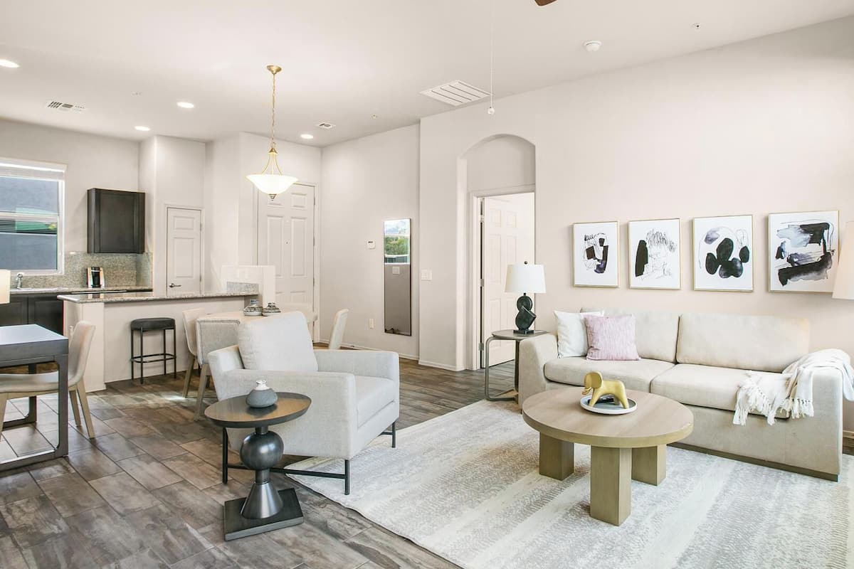 A modern living room with a sofa, chairs, a coffee table, and artwork on the wall.