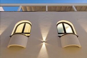 Fachada de edifício com duas janelas em arco e telhado plano.