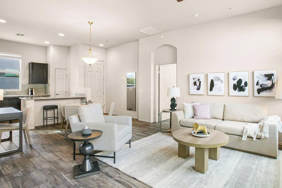 A modern living room with a sofa, chairs, a coffee table, and artwork on the wall.