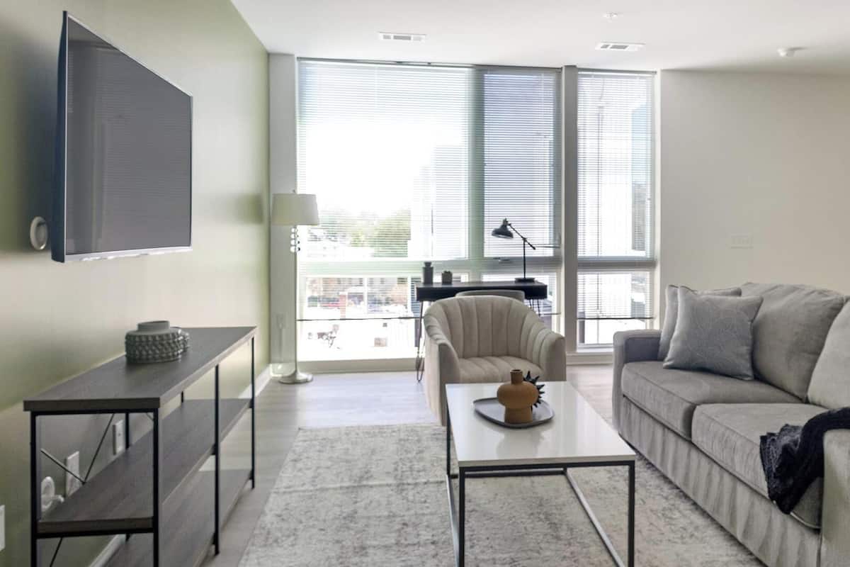 Una sala de estar moderna con sofá, mesa de centro y televisor.