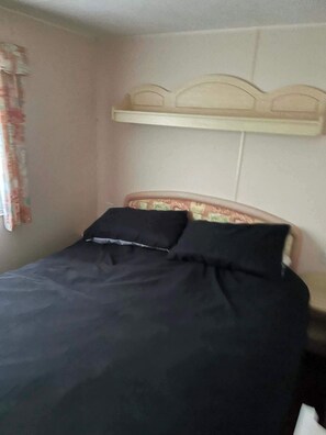 A bed with a headboard, a pillow, and a blanket. - Coastfield Park 3-bed Cabin Sleeps 8 w/ Parking (Skegness)