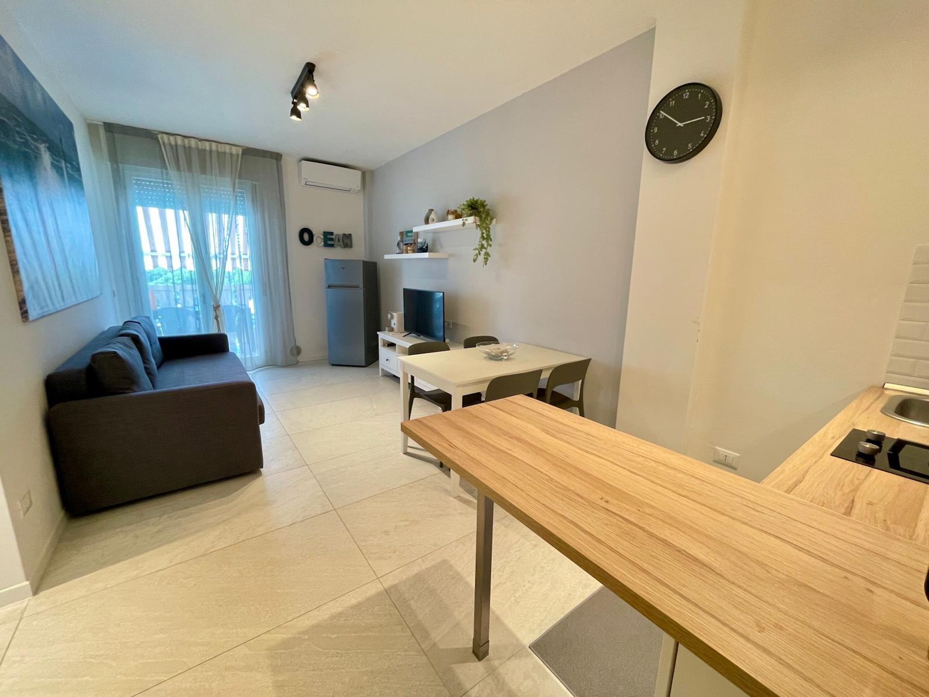 A modern apartment with a living area, a kitchen, and a dining space.