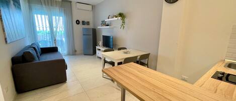 A modern apartment with a living area, a kitchen, and a dining space.