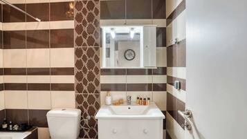 Un baño con inodoro, lavamanos y ducha.