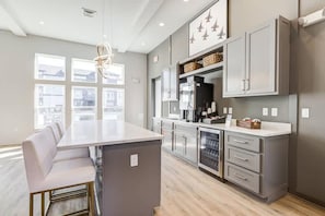 A modern kitchen with a central island, grey cabinetry, and a large window providing natural light. - Landing Modern 1BD in Warrington (Pensacola)