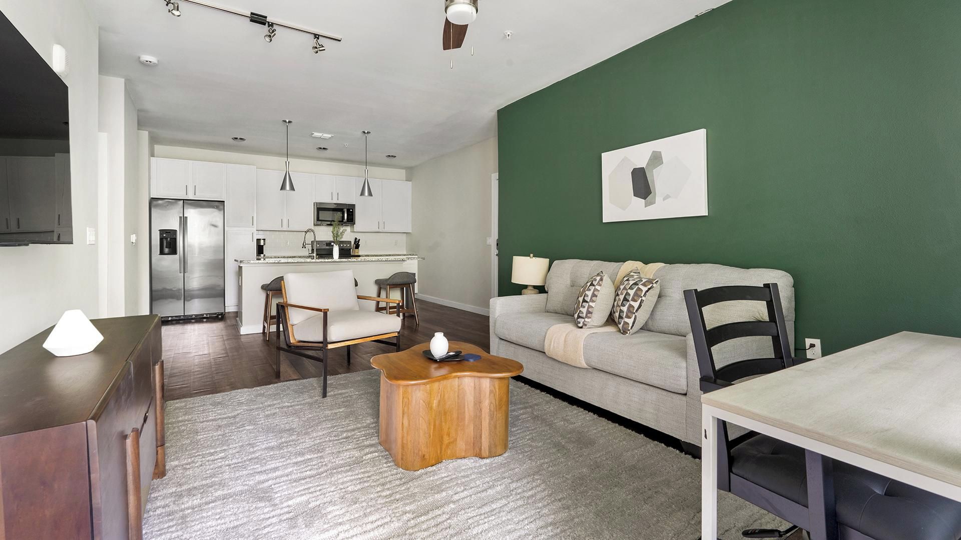 A modern apartment with a kitchen, dining area, and living room.