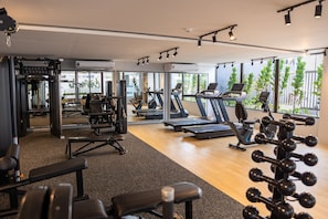 A gym with treadmills, weight machines, and a mirror wall. - Jardins Almares #325 - Cabo Branco by Carpediem (João Pessoa)