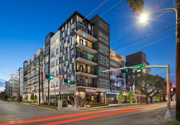 A multi-story building with commercial spaces on the ground floor, including a restaurant and a dental office. - Landing Incredible 1bd, Gym (Houston)