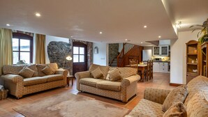 A spacious living area with two sofas, a dining table, and a kitchen in the background. - Roost, Quinceborough Farm (Widemouth Bay)