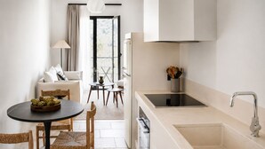 Una cocina moderna con un lavamanos, estufa y comedor con sillas y una mesa.