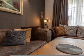 Un salon moderne avec un canapé, une table basse et un lampadaire.