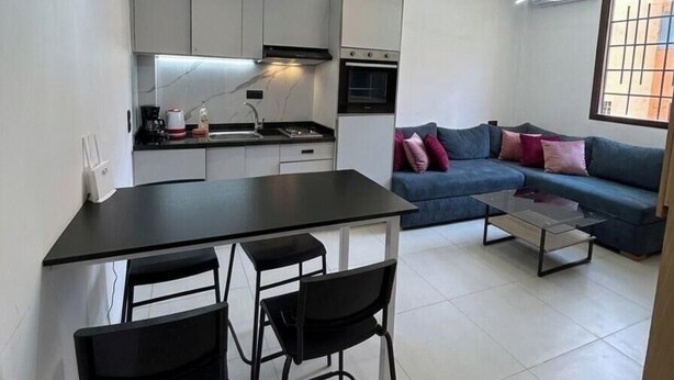 Cozinha moderna com área de refeições, um sofá e uma mesa de centro.