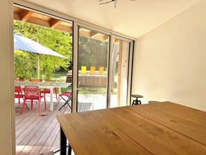 Une table en bois donnant sur un espace extérieur aménagé avec une table et des chaises.