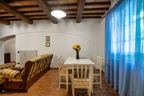 A dining area with a table, chairs, a bench, and a vase of flowers. - GuestHost - Il Casale dei Gelsi - Biancospino (San Martino In Campo)