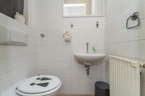 Ein Badezimmer mit Toilette, Waschbecken und Heizkörper.