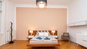 Una camera da letto con un letto di legno, due comodini con lampade, una sedia e un termosifone.