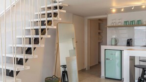 Ein modernes Interieur mit einer Treppe, einer kompakten Küche und einem Essbereich.