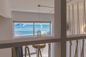Habitació amb un finestral gran que ofereix vistes al mar i vaixells.