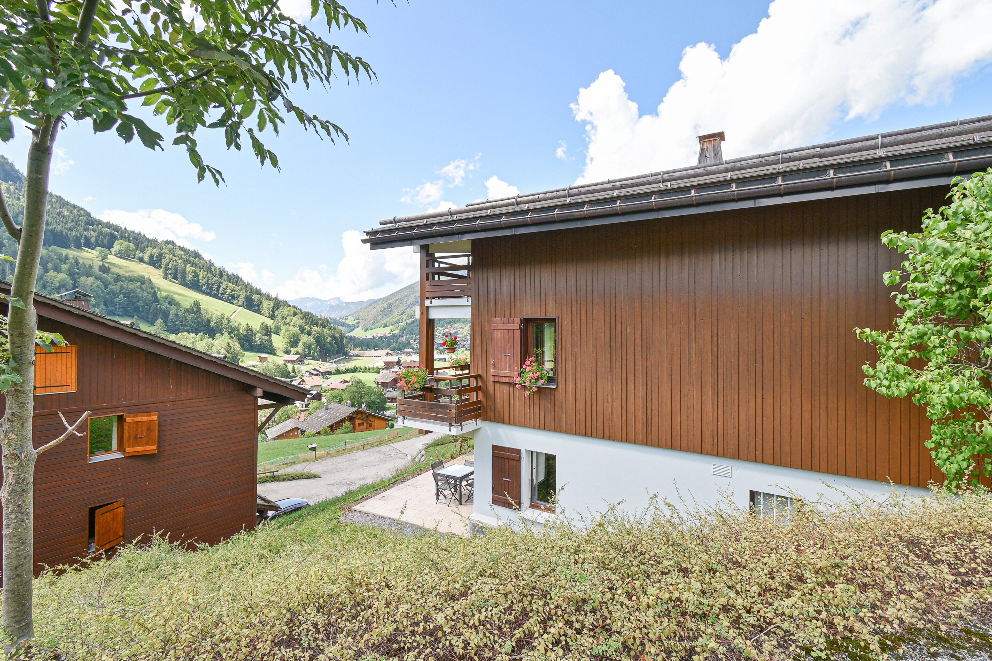 Eine Holzhütte mit Balkon mit Blick über ein Tal.