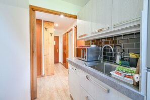 Eine Küche mit Einbauofen, Spüle und Holzschränken.